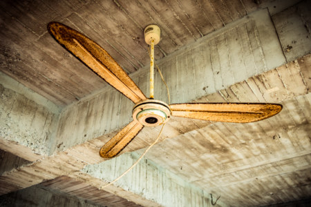 Raw concrete and a rusted fan