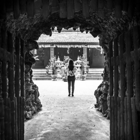 Peering through the sculpted gateway to a temple across from Han