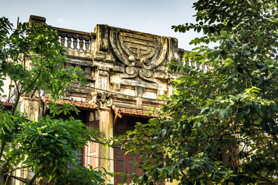 Ornate carvings on top of an old shophouse in Hanoi